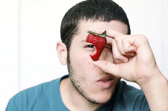 Mladý muž s nakousnutou jahodou | Zdroj: flickr.com | Copyright: half-blood prince